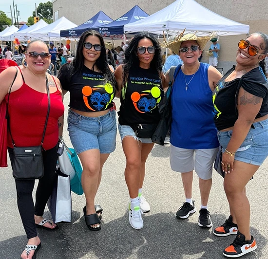 Paragon Home Care team members posing together at an outdoor community event on a sunny day