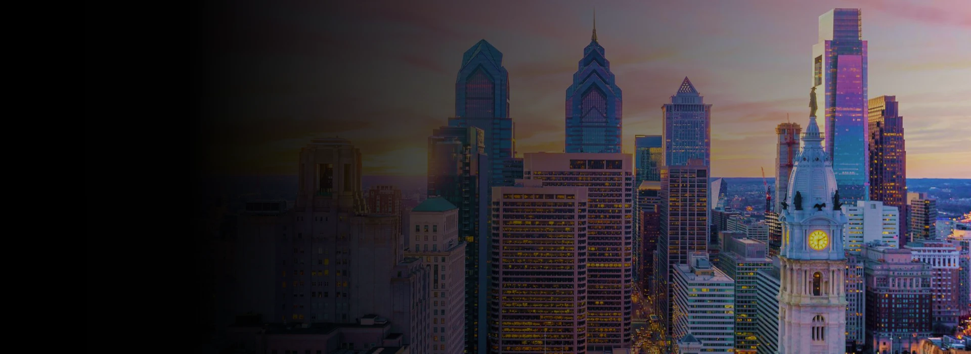 Philadelphia city skyline at sunset with City Hall tower and illuminated skyscrapers